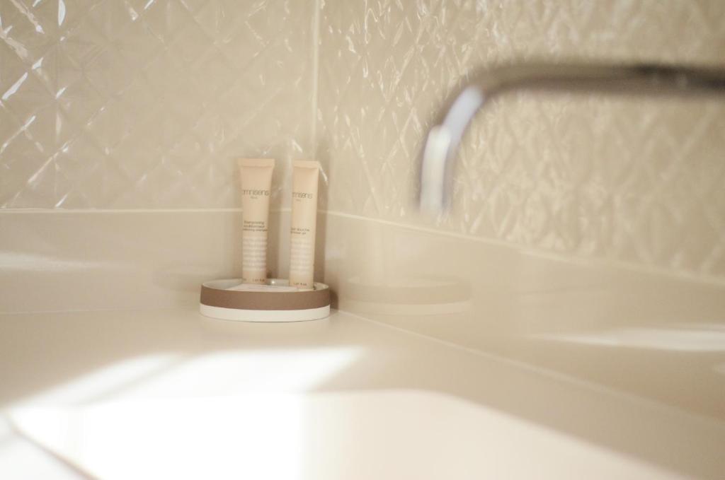 a bathroom with a sink and a tube of toothpaste at Hôtel le XIX in Béziers