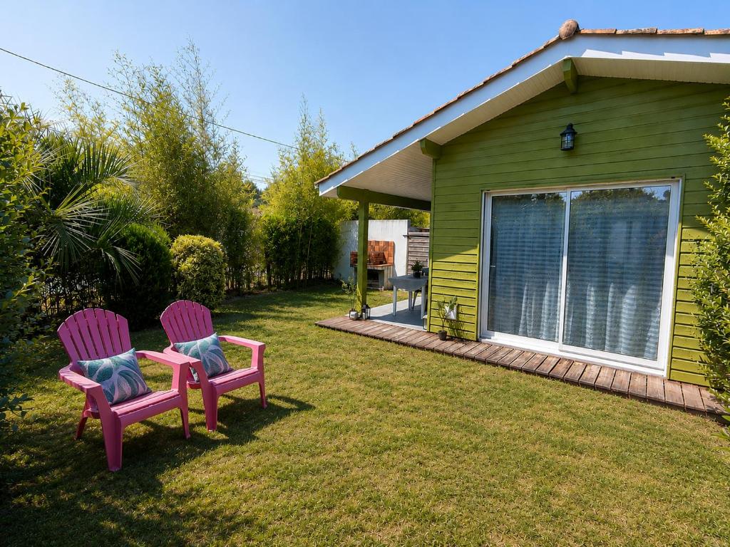 two chairs sitting in a yard next to a house at Gîte 2 pers avec jardin entre Bordeaux & Lacanau Océan in Brach