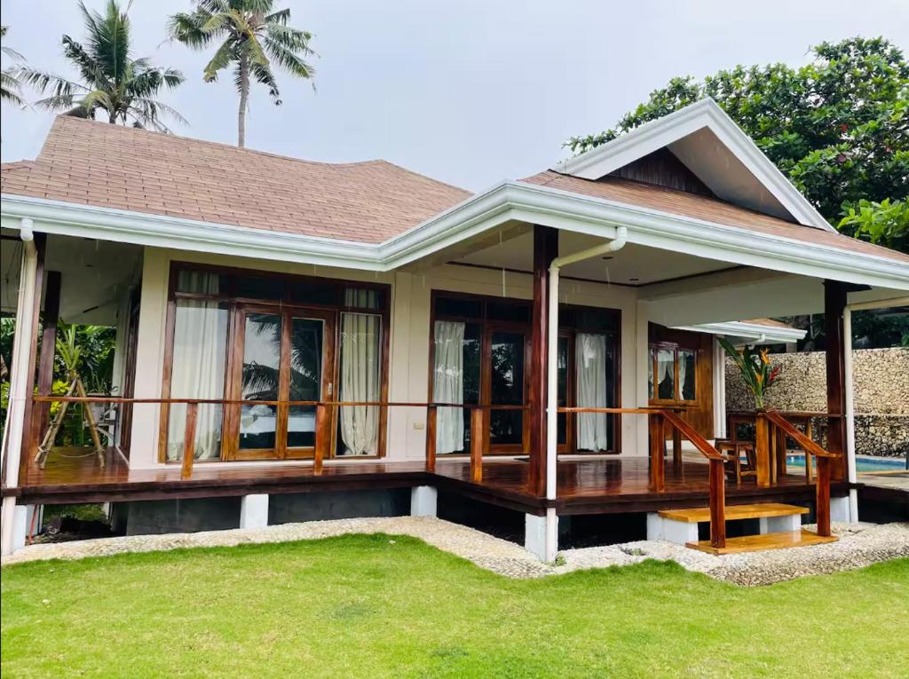 a home with a porch and green grass at Baha Bar in San Juan