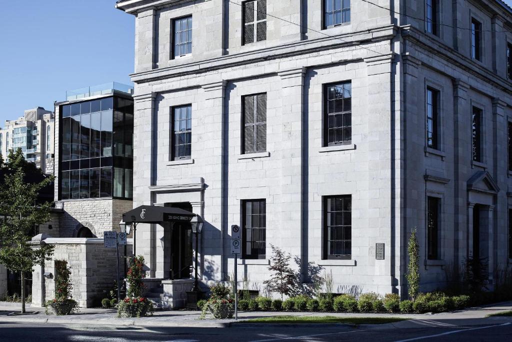 a white brick building on a city street at Frontenac Club, an Ascend Collection Hotel in Kingston