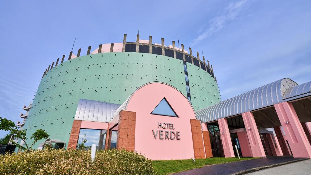 a round building with a sign in front of it at hotel VERDE in Arao