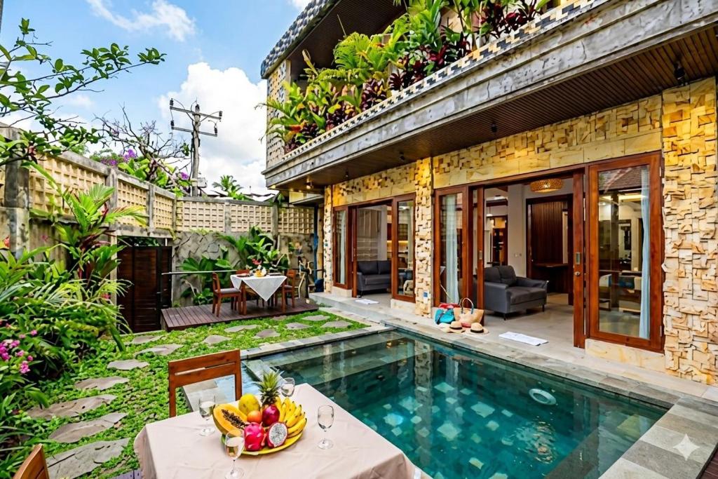 a villa with a swimming pool and a house at The Bulih Ubud in Ubud
