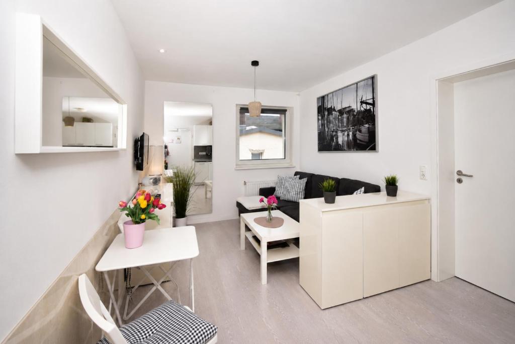a white living room with a couch and a table at Kirchenplatz 6 Apartment 18 Atlantic in Warnemünde