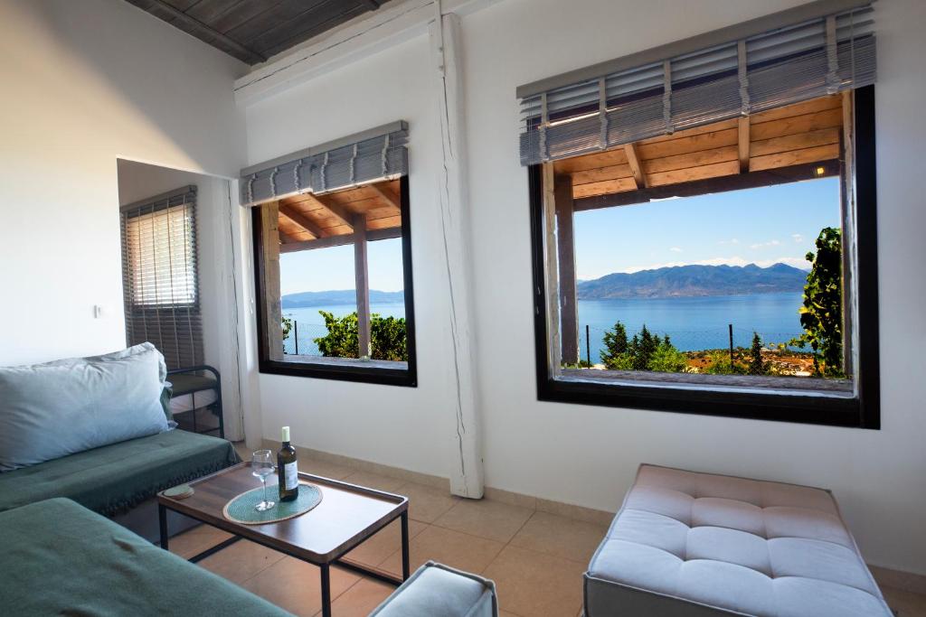 a living room with a couch and two windows at Helios stone house in Aegina