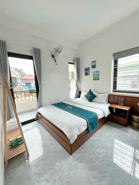 a bedroom with a bed and a large window at Lộc phát hotel mộc châu in Làng Môn