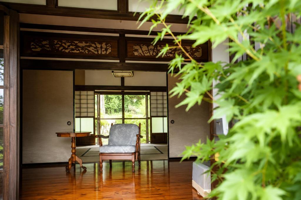 a living room with a chair and a table at 三ツ峠の宿 in Nishikatsuracho