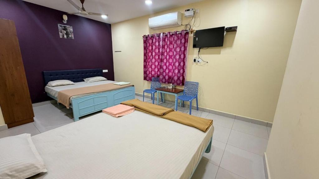 a room with two beds and a tv in it at Gravity Groups Core VHR Residency in Puducherry Airpoert