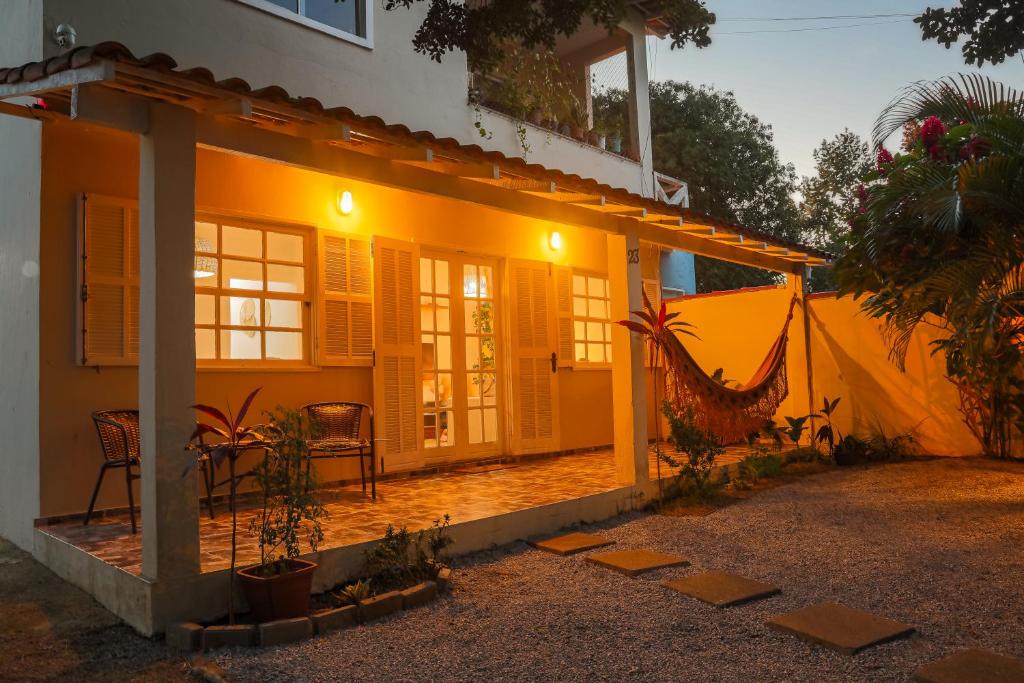 a house with a patio and a hammock in front of it at Casa Laguna - Geribá in Búzios