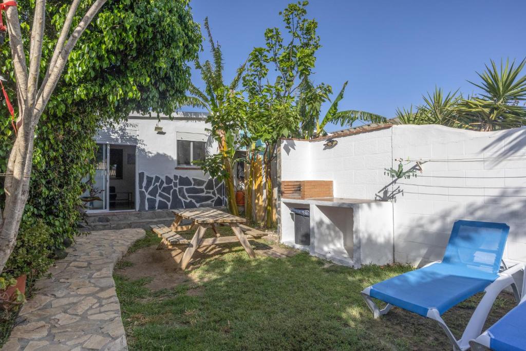 a yard with a blue chair and a table at Sunwaves 4 - Casa Duna in El Palmar