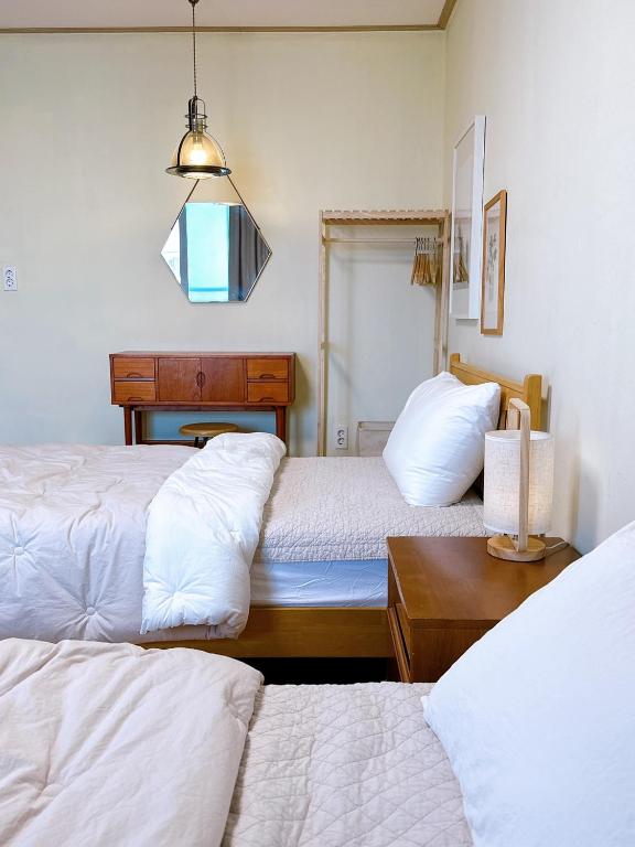 a bedroom with two beds and a light fixture at 마음스테이 in Taesuha-dong