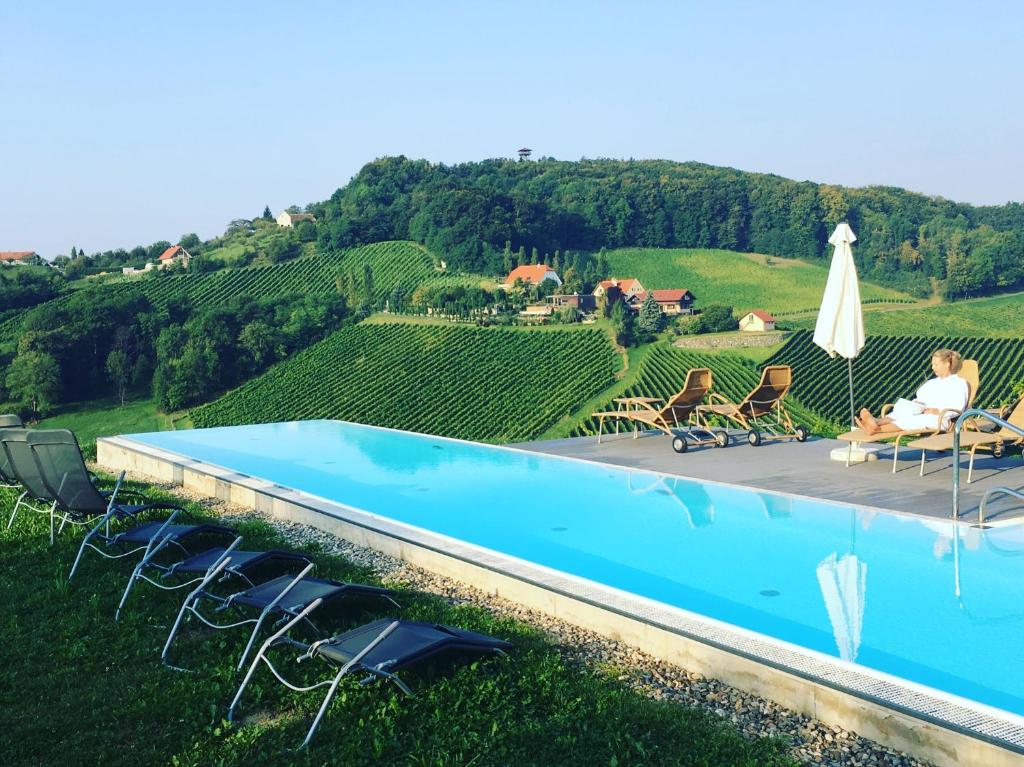 a couple sitting in chairs next to a swimming pool at MASTER Suite CasaFux am Graßnitzberg in Grassnitzberg