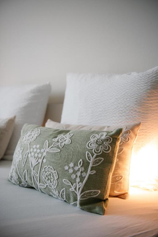 ein Bett mit zwei Kissen und einer Lampe darauf in der Unterkunft Between Flanders Walls in Ypern