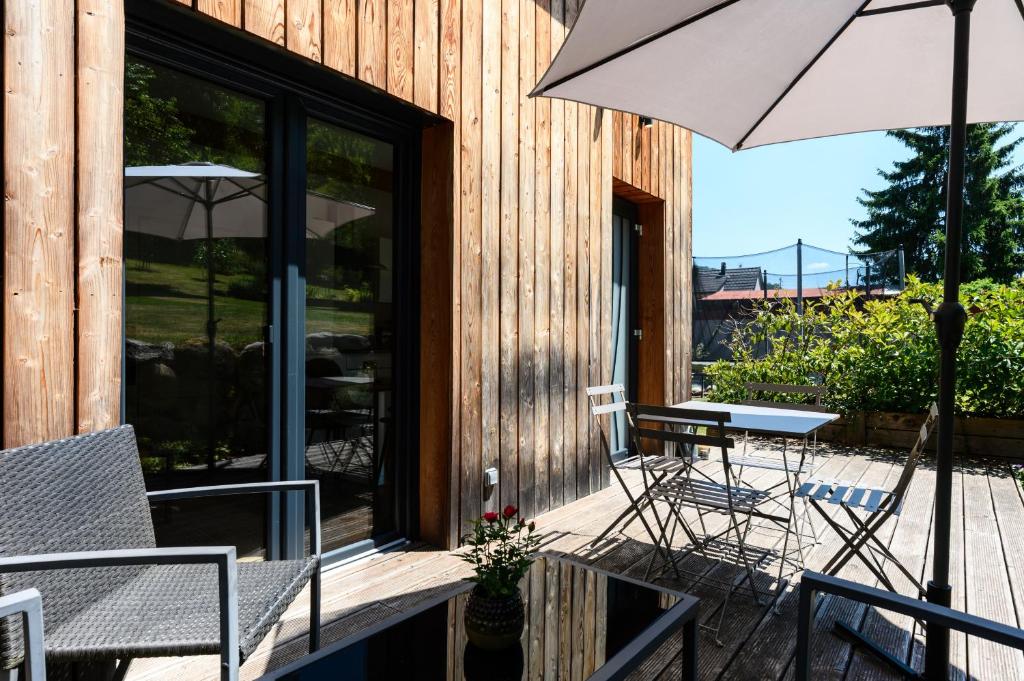a patio with a table and chairs and an umbrella at Flora Gîte in Kaysersberg