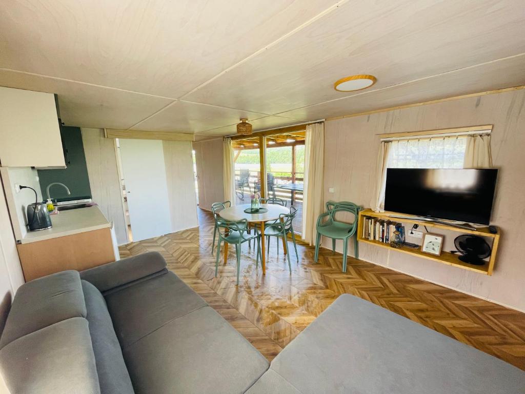 a living room with a couch and a table at Mobilheim Luna - Výrovická přehrada in Výrovice