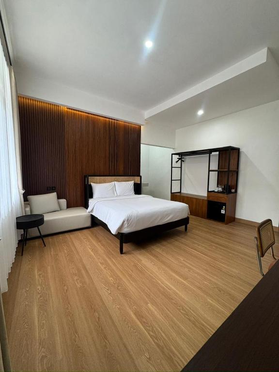 a bedroom with a large bed and a wooden wall at And Living Hotel in Kejayan