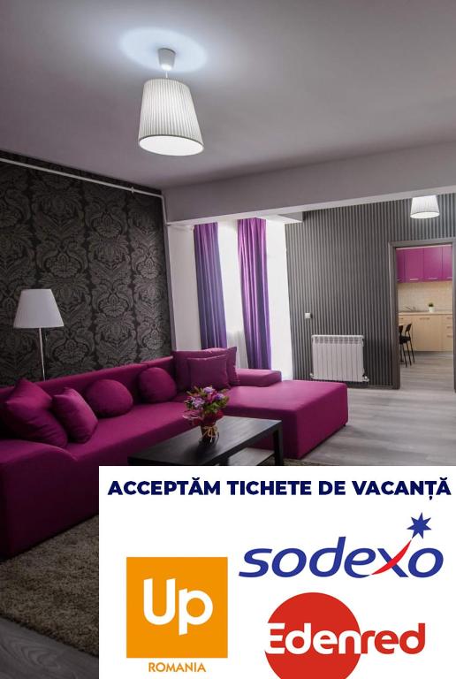 a living room with a purple couch and a table at Magnum Residence in Mamaia Sat/Năvodari