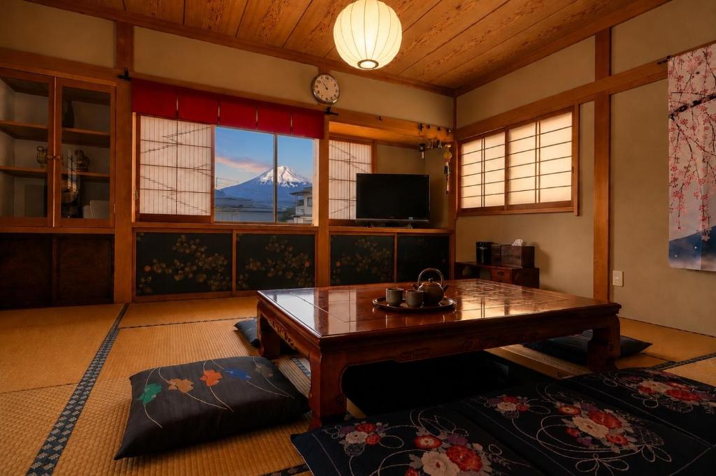a living room with a table and a mountain view at 富士と宿と Fuji to Yado to in Fujiyoshida
