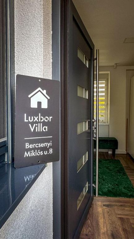 a door to a building with a sign on it at Luxbor Villa in Eger