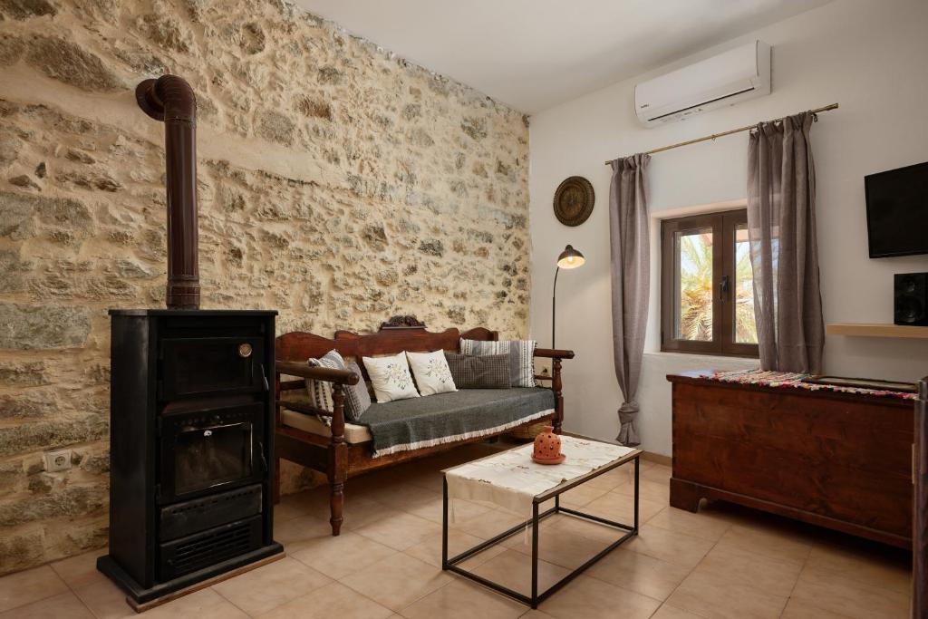 a living room with a couch and a wood stove at Chara Stone House in Kharasón