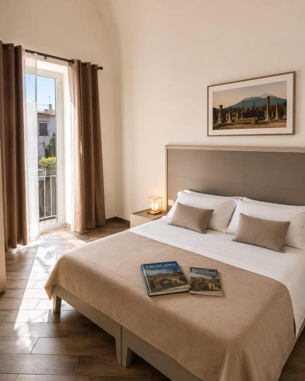 a bedroom with a large bed with two books on it at Palazzo Ferretti - Herculaneum Ruins in Ercolano