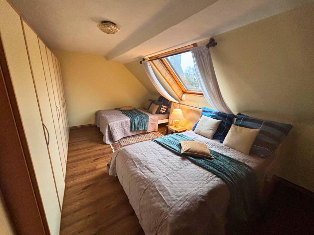 a small bedroom with two beds and a window at EifelRuhe 2 - Komfortable Ferienunterkunft für bis zu 10 Gäste mit 4 Schlafzimmern, großer Küche und genug Parkplätzen - ideal für Gruppen und Familien, Hunde zulässig in Losheim