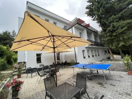 a patio with a table and a large umbrella at Penzión Stálica in Bojnice