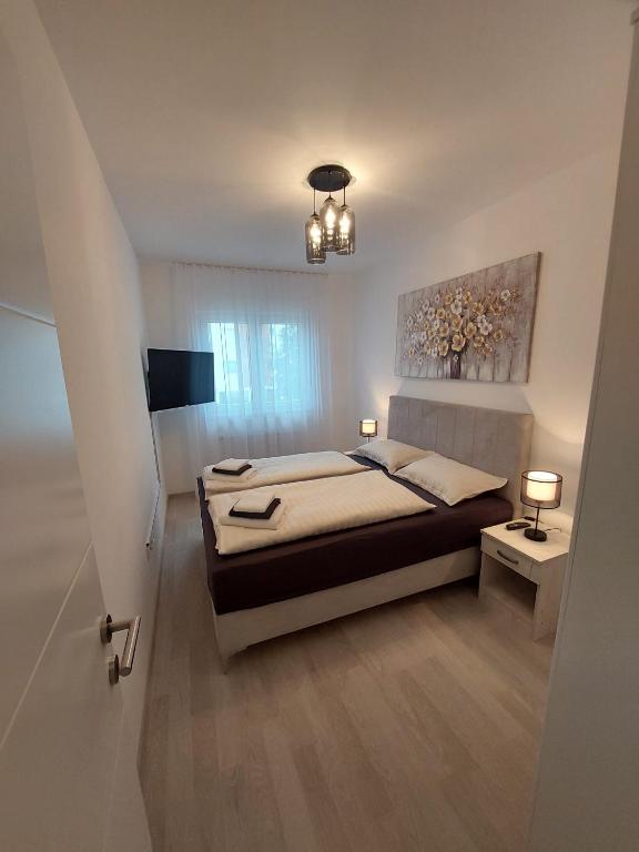 a bedroom with a bed and a chandelier at Apartman Gordana i Andreas in Banja Koviljača