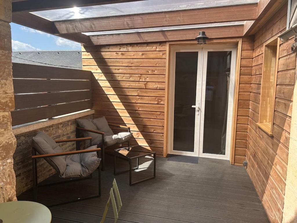 a wooden deck with chairs and a sliding glass door at Refuge de la Basilique in Charleville-Mézières