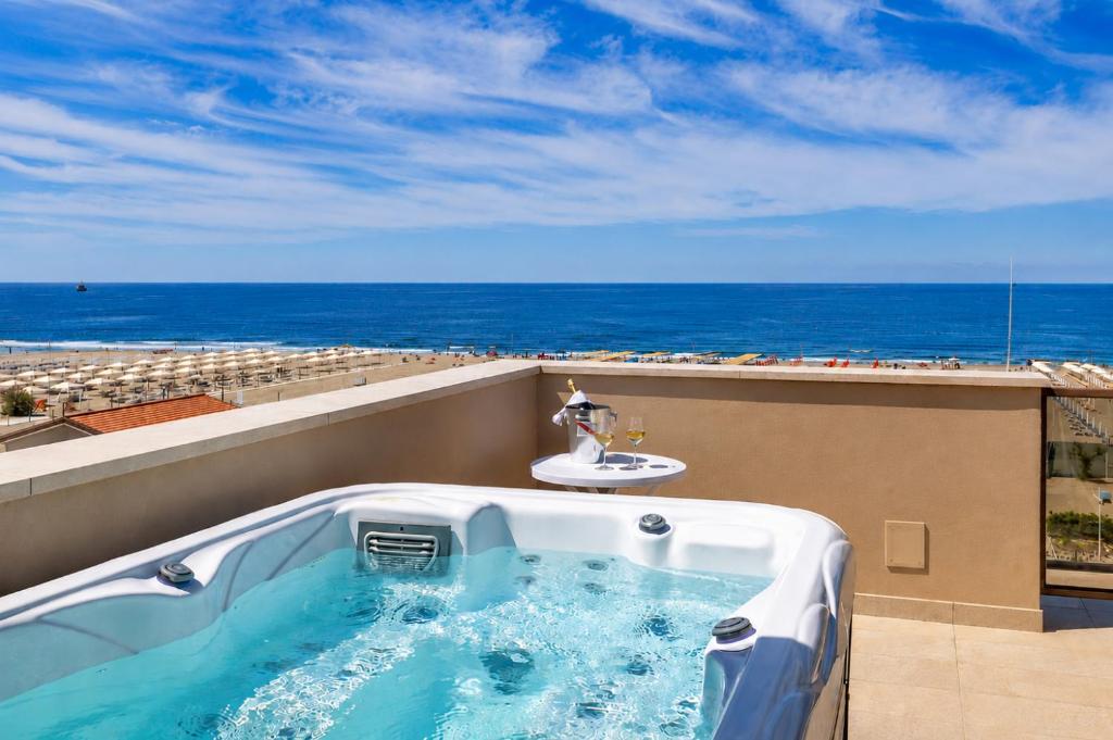 a hot tub on a balcony with the ocean at Junior Suite Hotel Biagi in Lido di Camaiore