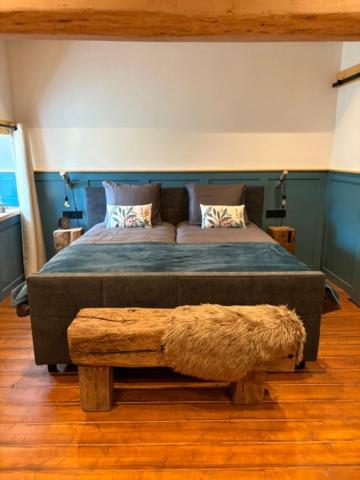 a bedroom with a large bed and a bench at Vue sur la colline La-Roche in Bouzais