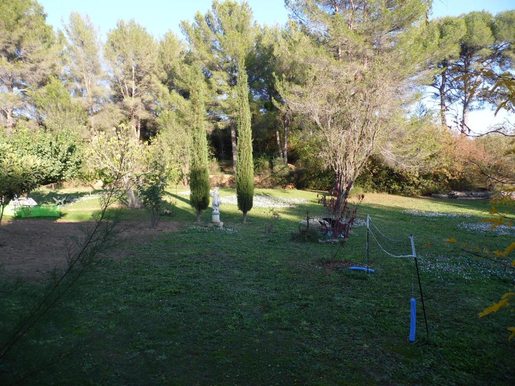 a park with trees and a swing set in the grass at le Mas du Pin Vert in Aubagne
