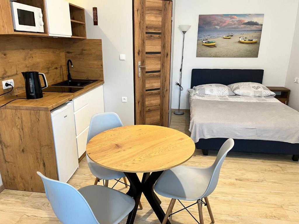 a small kitchen with a table and chairs in a room at Pokoje Gościnne U RYBAKA in Karwia