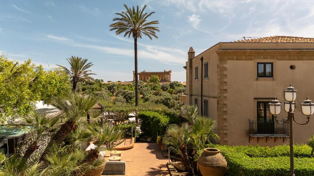 a resort with a palm tree and a building at Villa Athena Resort in Agrigento