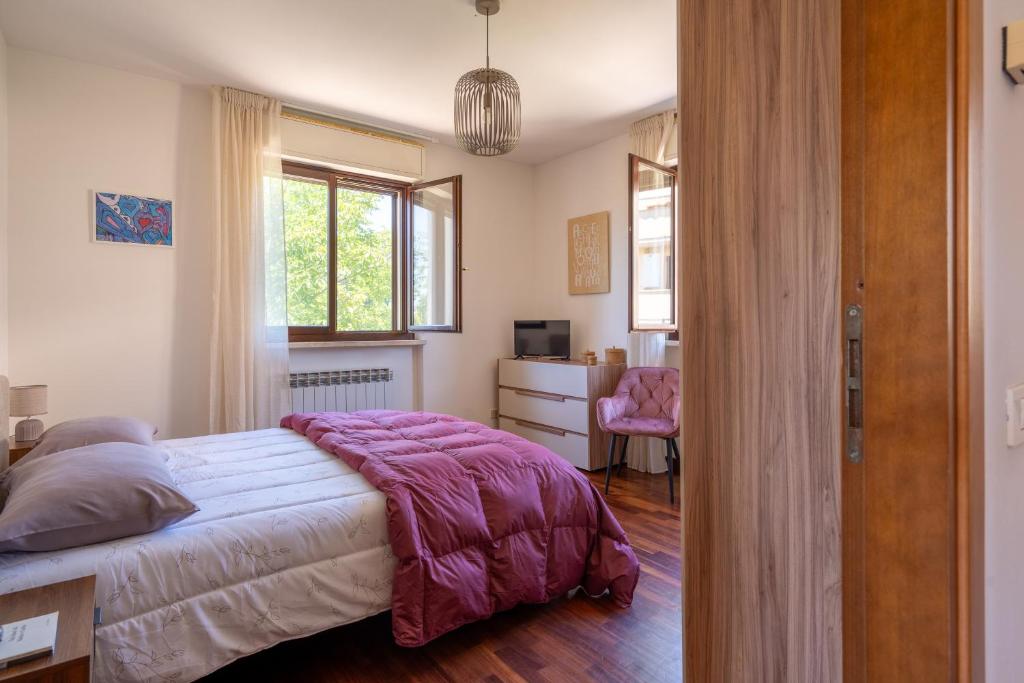 a bedroom with a bed and a desk and window at Appartamento Posta del Lago in Passignano sul Trasimeno