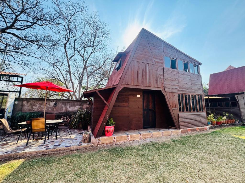 ein Haus im Scheunenstil mit Tisch und Stühlen in der Unterkunft Cabañas Tlacult Gatü in Tepoztlán
