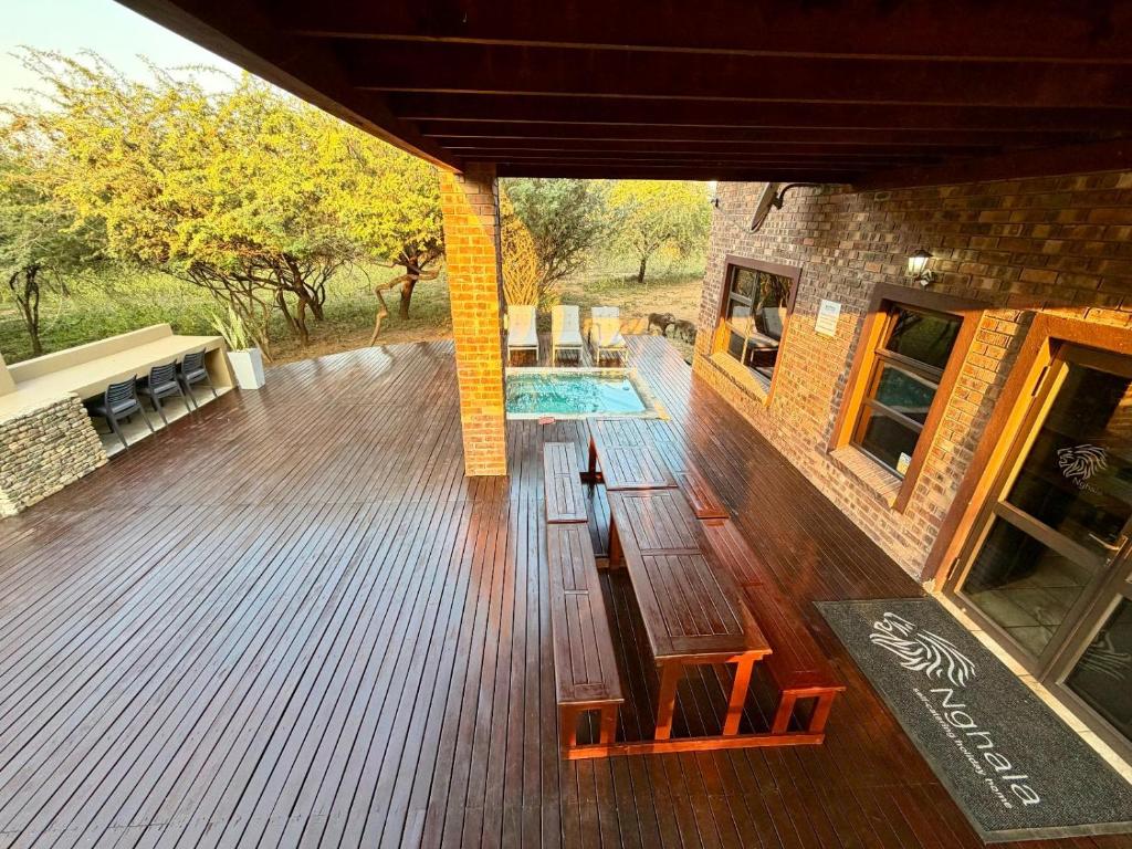 an outdoor deck with a pool and a building at Nghala Self-catering Holiday Home in Marloth Park
