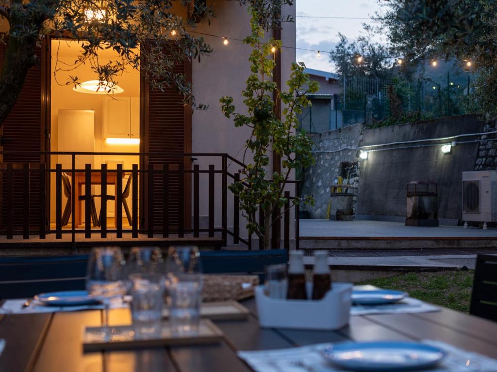 a table with plates and glasses on a patio at Casa Rita - Casa vacanze - free parking terrazze e giardino area barbecue TOP CLASS in Predore