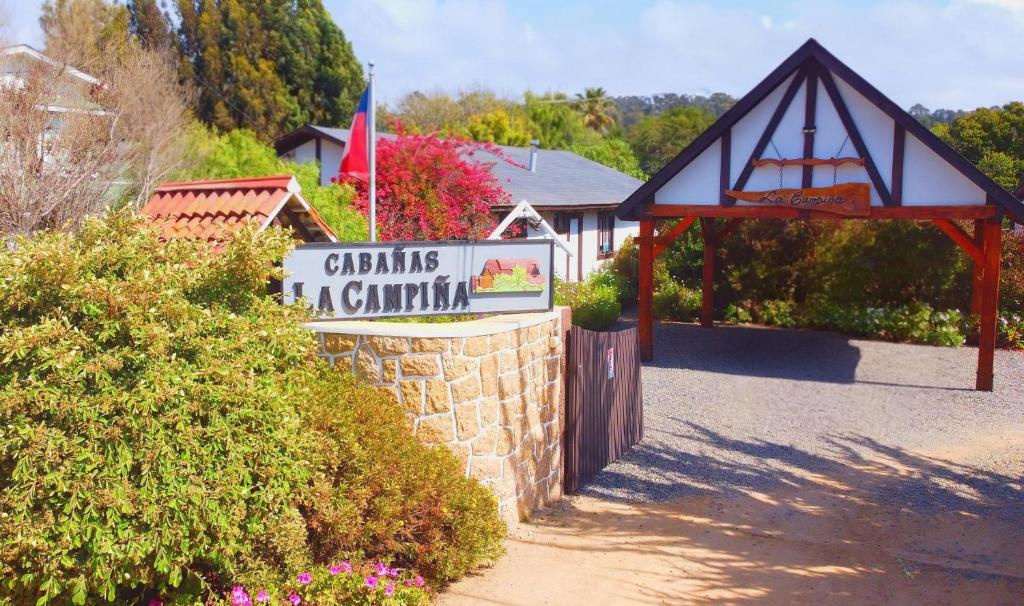 a sign in front of a building with a gate at Cabañas La Campiña Algarrobo in Algarrobo
