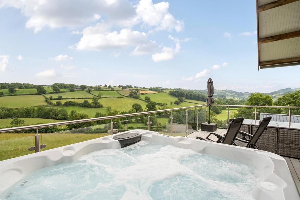 a jacuzzi tub on a balcony with a view at Bwncath in Welshpool