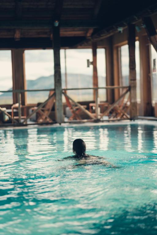 a person in the water in a swimming pool at Spidsbergseter Resort Rondane in Venabygd