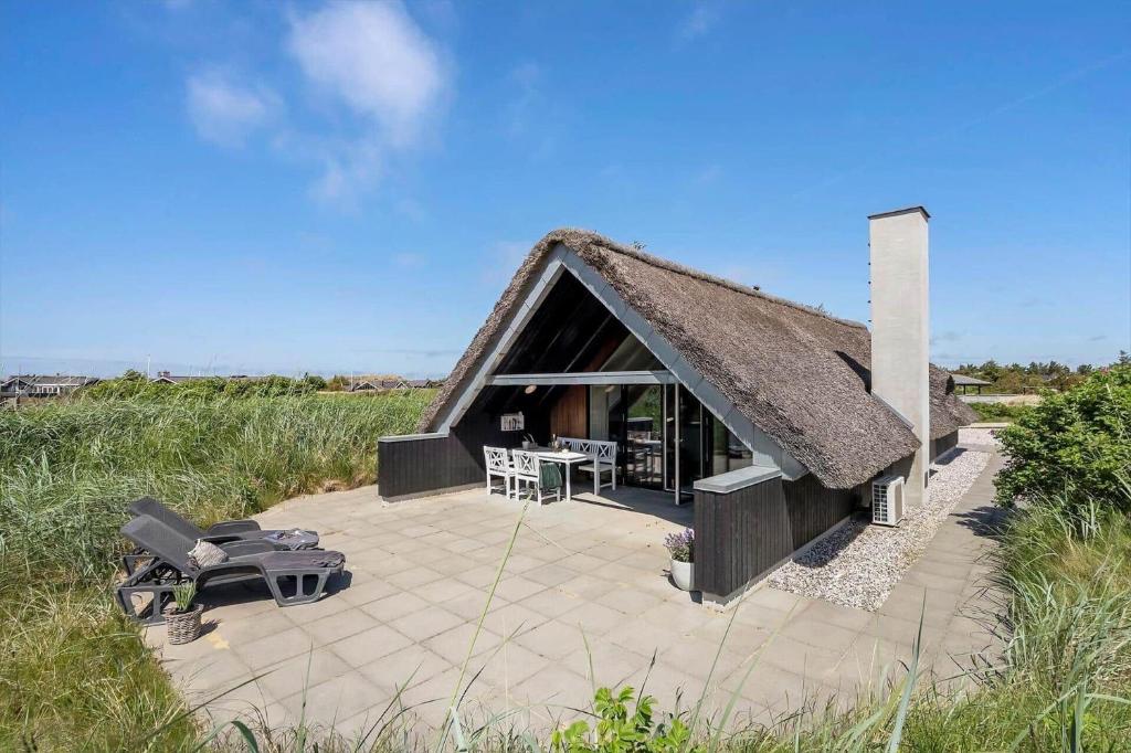 a house with a thatched roof in a field at 299-Ringkobing-Havklitvej-24 in Klegod
