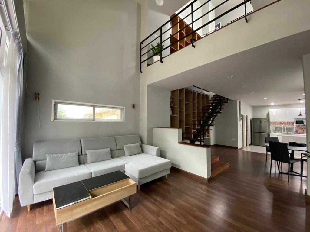 a living room with a couch and a staircase at Home Sukhumvit 49 Soi 14 in Bangkok