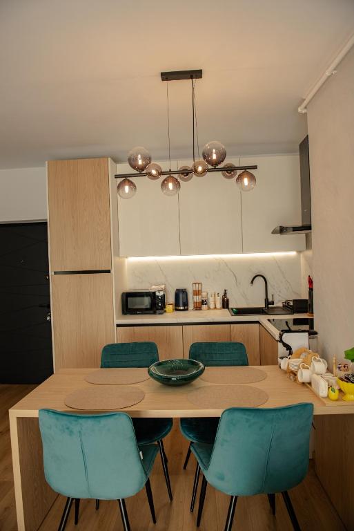 a kitchen with a wooden table and blue chairs at RIVER VIEW & Private Parking - Baia Mare in Baia Mare