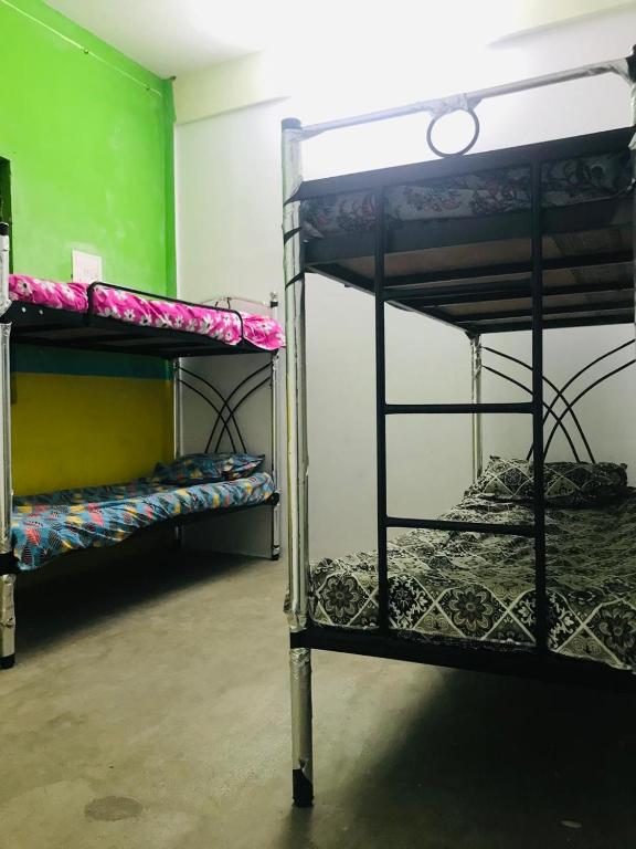 two bunk beds in a room with a green wall at HR home stay in Chennai