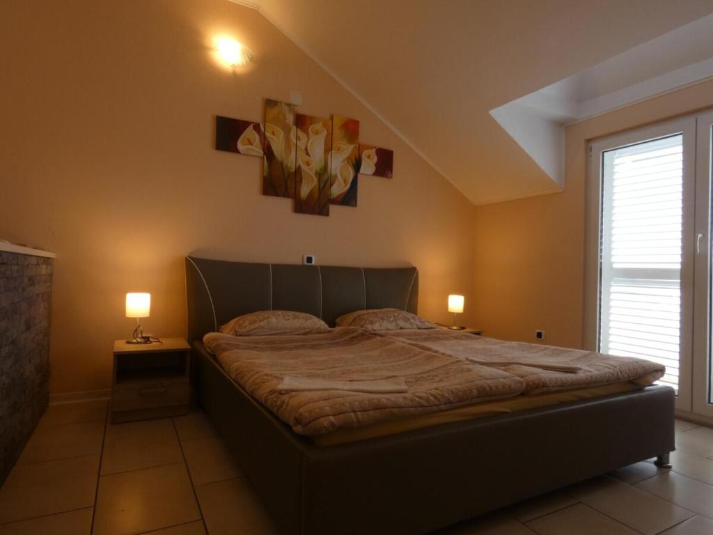 a bedroom with a large bed with two lamps at Nature sunset apartment in Ubli