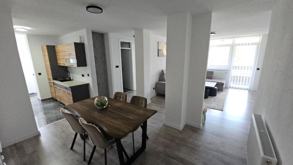 a dining room and living room with a table and chairs at Stan na dan Tuzla in Tuzla