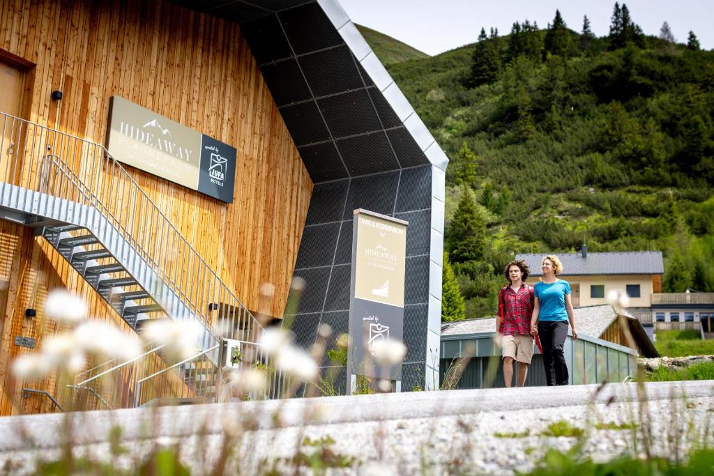 two women are standing outside of a building at Hideaway Planneralm operated by JUFA Hotels in Planneralm