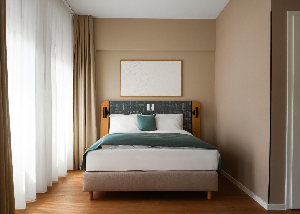 a bedroom with a large bed with a whiteboardigunigunigunigun at Limehome Berlin Klosterstraße in Berlin