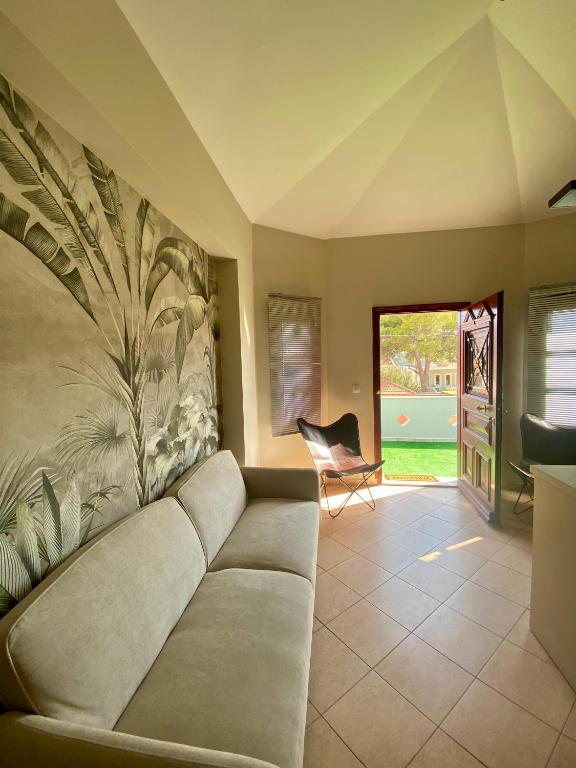 a living room with a couch and a chair at Happinest Private Apartment II in Kalymnos