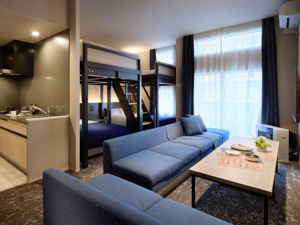 a living room with a couch and a bunk bed at Minn Sapporo Odori W14 in Sapporo